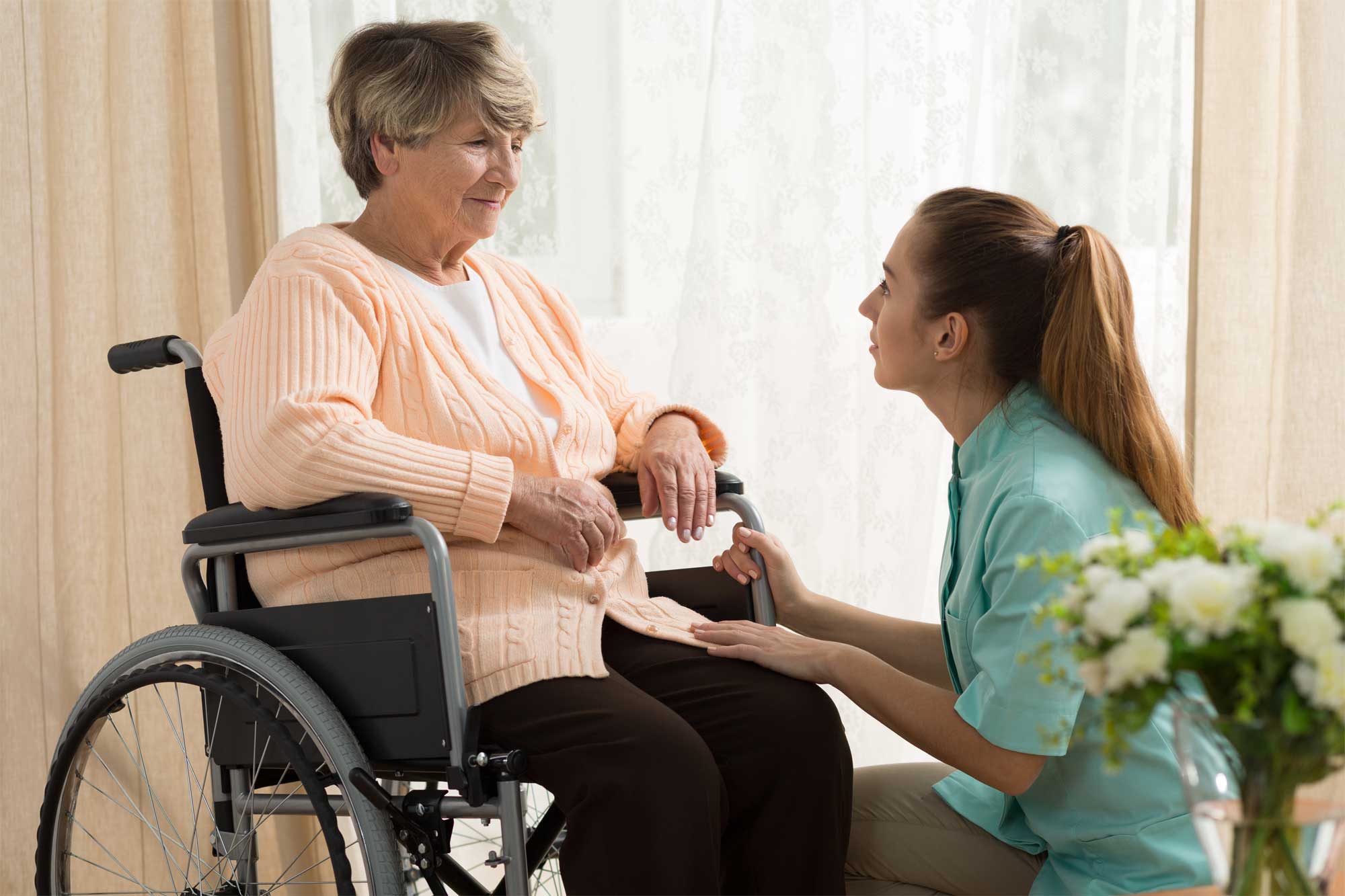 A social worker talking with a senior in a wheelchair